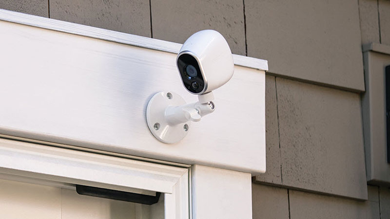 A CCTV camera attached to the top-right corner of a door.